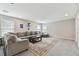 Spacious living room features a large gray sectional, neutral walls, natural light, and a decorative area rug at 19316 Eagle Creek Ln, Tampa, FL 33647