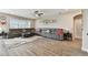 Spacious living room with a large gray sectional, wood-look tile flooring, and ample natural light at 19316 Eagle Creek Ln, Tampa, FL 33647