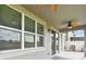 Covered patio shows ceiling fan, exterior windows and sliding glass door leading to the backyard space at 19316 Eagle Creek Ln, Tampa, FL 33647