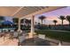 Relaxing pool area with pergolas, palm trees, and elegant patio furniture at sunset at 2204 Paravane Way, Wesley Chapel, FL 33543