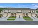 A row of beautiful townhomes with gray roofs and matching garages with landscaping along the driveways at 2204 Paravane Way, Wesley Chapel, FL 33543