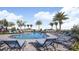 Inviting community pool with comfortable lounge chairs and lush landscaping at 2204 Paravane Way, Wesley Chapel, FL 33543