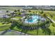 Aerial view of a luxurious community pool with palm trees and comfortable lounge chairs at 2204 Paravane Way, Wesley Chapel, FL 33543