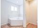 Bright bathroom featuring a corner bathtub with tile surround and a window for natural light at 22465 Lewiston Ave, Port Charlotte, FL 33952