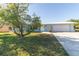 Charming home featuring a well-maintained lawn, mature tree, and a two-car garage at 22465 Lewiston Ave, Port Charlotte, FL 33952