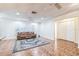 Bright living room with stylish blue rug, fan, shuttered windows, and a comfortable brown leather sofa at 22465 Lewiston Ave, Port Charlotte, FL 33952