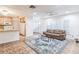 Open-concept living room with a leather sofa, area rug, and access to the kitchen at 22465 Lewiston Ave, Port Charlotte, FL 33952