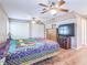 The main bedroom features dual ceiling fans, shuttered windows, dresser storage and tv at 22465 Lewiston Ave, Port Charlotte, FL 33952