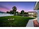 Spacious backyard with lush lawn, palm tree, and canal view, perfect for outdoor relaxation and entertaining at 250 W Canal Dr, Palm Harbor, FL 34684