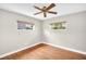 Bright bedroom featuring hardwood floors, a ceiling fan, and two windows at 250 W Canal Dr, Palm Harbor, FL 34684