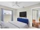 Bright bedroom featuring a mounted flat screen and white bedding with a bright blue cabinet at 250 W Canal Dr, Palm Harbor, FL 34684