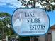 Lake Shore Estates community sign featuring a heron and community information surrounded by lush landscaping at 250 W Canal Dr, Palm Harbor, FL 34684