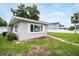 Exterior view of gray home with white trimmed windows and green lawn at 250 W Canal Dr, Palm Harbor, FL 34684