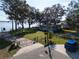 View of a charming home near the waterfront with a blue car parked in the driveway surrounded by beautiful trees at 250 W Canal Dr, Palm Harbor, FL 34684