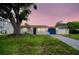 Charming single-story home featuring a well-maintained lawn, blue garage door, and inviting front porch at 250 W Canal Dr, Palm Harbor, FL 34684