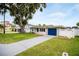 Charming home with a well-manicured lawn and a bright blue garage door at 250 W Canal Dr, Palm Harbor, FL 34684