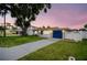 Well-lit front view with green grass, a walkway, and a blue garage door at 250 W Canal Dr, Palm Harbor, FL 34684