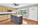 Bright kitchen with tan cabinets, granite countertops, blue island, and hardwood floors at 250 W Canal Dr, Palm Harbor, FL 34684