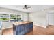 Kitchen with island, seating, tan cabinets, granite countertops, and hardwood floors at 250 W Canal Dr, Palm Harbor, FL 34684