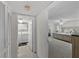 Hallway view to the laundry room with washer and dryer and main bedroom with ceiling fan at 2693 Sabal Springs Cir # 201, Clearwater, FL 33761