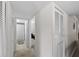 Hallway leading to a bathroom with shower/tub combo, white closet doors, and neutral carpet at 2693 Sabal Springs Cir # 201, Clearwater, FL 33761
