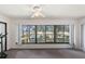 Bright living room with large windows offering scenic outdoor views and ceiling fan at 2693 Sabal Springs Cir # 201, Clearwater, FL 33761