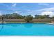 Large community pool with clear blue water, plenty of seating and surrounding trees at 2693 Sabal Springs Cir # 201, Clearwater, FL 33761