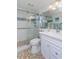 Modern bathroom with glass shower, white vanity, stone tile flooring, and updated fixtures at 2722 Sand Hollow Ct # 2722, Clearwater, FL 33761