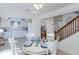 Bright dining area featuring white table set for four, open to kitchen and staircase at 2722 Sand Hollow Ct # 2722, Clearwater, FL 33761