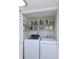 Convenient laundry closet with washer, dryer, storage shelves, and bi-fold doors at 2722 Sand Hollow Ct # 2722, Clearwater, FL 33761