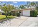 Cozy single-story home features an attached garage, well-maintained driveway, and mature landscaping at 3072 Keene Park Dr, Largo, FL 33771