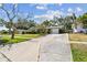 A cozy home with a well-maintained driveway and mature trees, providing ample shade and curb appeal at 3072 Keene Park Dr, Largo, FL 33771