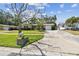 A well-manicured lawn and mature trees surround this cozy single-story home, enhancing its curb appeal at 3072 Keene Park Dr, Largo, FL 33771