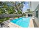 The backyard pool area features an inviting pool, patio, and privacy fence, complemented by lush tropical landscaping at 3072 Keene Park Dr, Largo, FL 33771