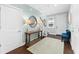 Inviting foyer with a table and a round mirror, leading to a staircase with dark treads at 310 S Habana Ave # 5, Tampa, FL 33609