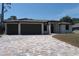 Newly constructed home with a paver driveway leading to a three-car garage at 3125 Tucson Rd, North Port, FL 34286