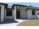 Inviting entrance with a covered porch featuring modern design elements and paver walkway at 3125 Tucson Rd, North Port, FL 34286