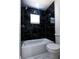 Modern bathroom with black marble tile shower, a tub, and a toilet at 3145 Munson St, New Port Richey, FL 34655