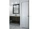 Modern bathroom features a dark wood vanity with stone countertops and white marble floors at 3145 Munson St, New Port Richey, FL 34655