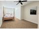 Cozy bedroom with a four-poster bed, ceiling fan, and a double-door closet at 3145 Munson St, New Port Richey, FL 34655