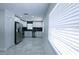Modern kitchen featuring stainless steel appliances, white cabinetry, and striking black backsplash at 3145 Munson St, New Port Richey, FL 34655