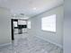 Open living area showcasing sleek marble floors and an adjacent kitchen with black accents at 3145 Munson St, New Port Richey, FL 34655