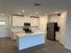 Modern kitchen featuring white cabinets, stainless steel appliances, and a center island with a sink at 32024 Griffin Sands Ln, San Antonio, FL 33576