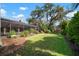 Expansive backyard with lush green grass, mature trees, and a screened-in lanai, perfect for outdoor entertaining at 3427 Forest Bridge Cir, Brandon, FL 33511
