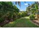 Private backyard oasis featuring a well-maintained lawn, mature trees, and lush landscaping, creating a serene retreat at 3427 Forest Bridge Cir, Brandon, FL 33511