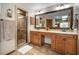 Bathroom featuring double sinks, a large mirror, vanity, and a tiled glass-enclosed shower at 3427 Forest Bridge Cir, Brandon, FL 33511