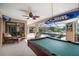 This enclosed patio features a pool, rocking chair, ceiling fan and billiard table at 3427 Forest Bridge Cir, Brandon, FL 33511
