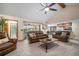 Spacious living room featuring comfortable seating, a ceiling fan, and access to the kitchen and outdoor patio at 3427 Forest Bridge Cir, Brandon, FL 33511