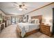 Bright main bedroom with carpet, desk, king bed, ceiling fan, and sliding glass doors to the patio at 3427 Forest Bridge Cir, Brandon, FL 33511