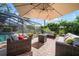 An outdoor patio with comfortable seating and a fire pit with an enclosed pool in the background at 3427 Forest Bridge Cir, Brandon, FL 33511